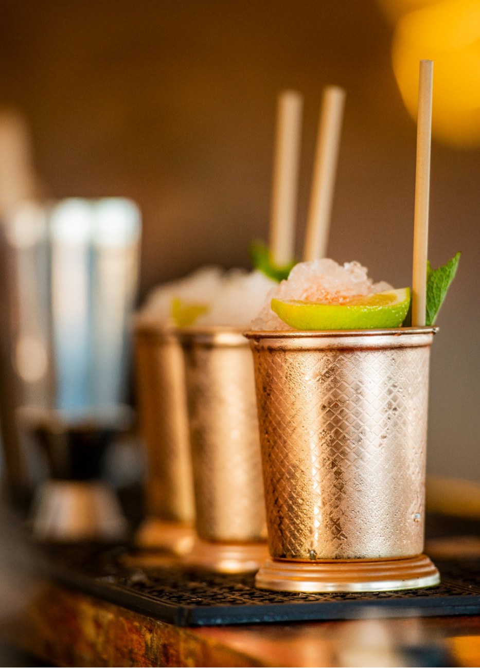 Cocktails mule servis en mugs de cuivre avec glace pilee, citron vert et menthe