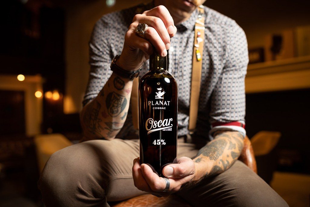 OSCAR Planat Cognac Bartender 45% — bouteille présentée par un bartender, photographie Antoine Ollier